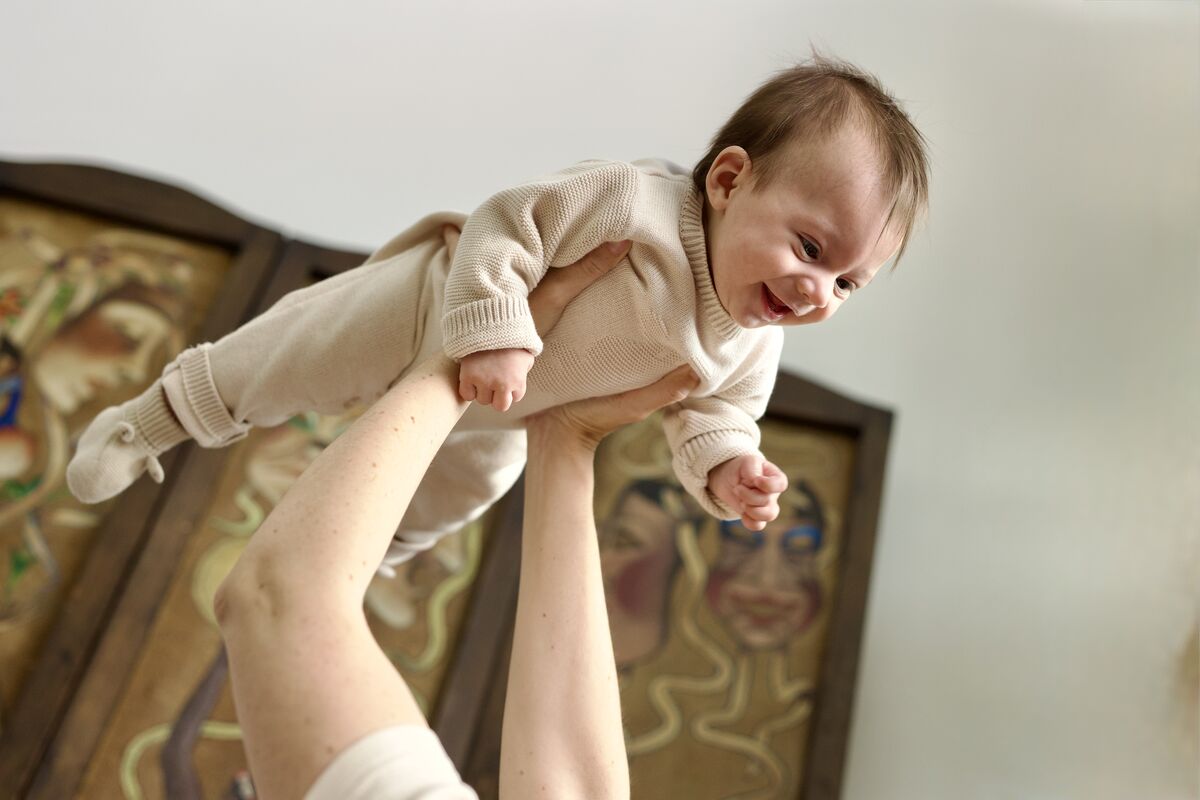 Baby lifted in the air, laughing